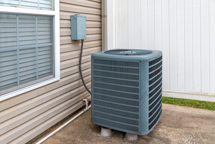 Central air conditioner condenser unit installed outside a home, used for BTU sizing calculations
