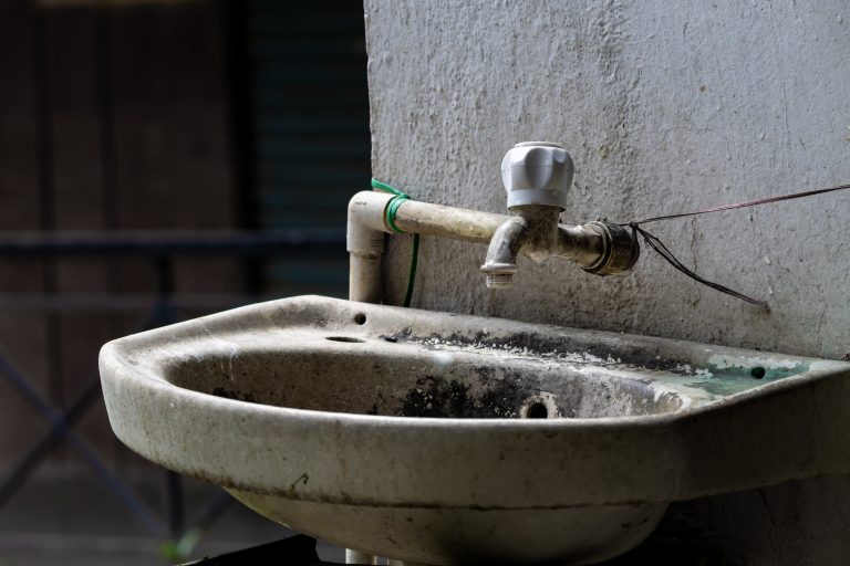 Sink and faucet running tap water