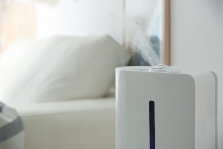 Whole-house humidifier emitting cool mist in a bedroom