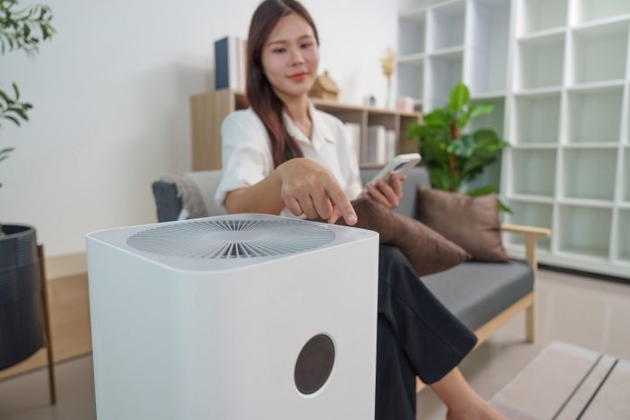 Woman operating an air purifier in her living room