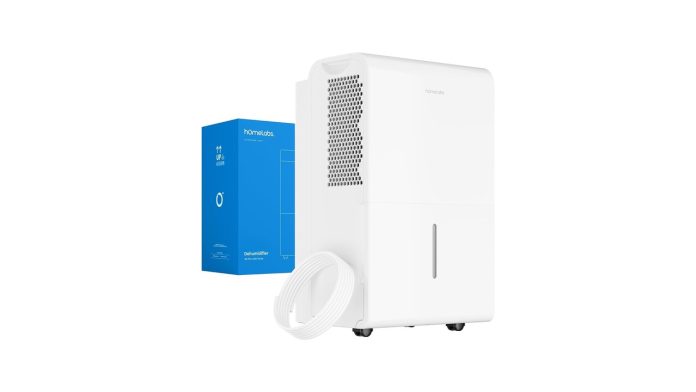 A dehumidifier with a drain hose pumping water up to a wall-mounted utility sink